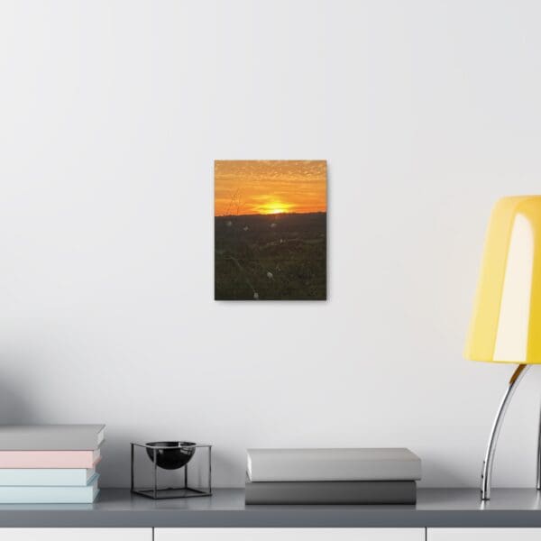 A painting of the sun setting over a field