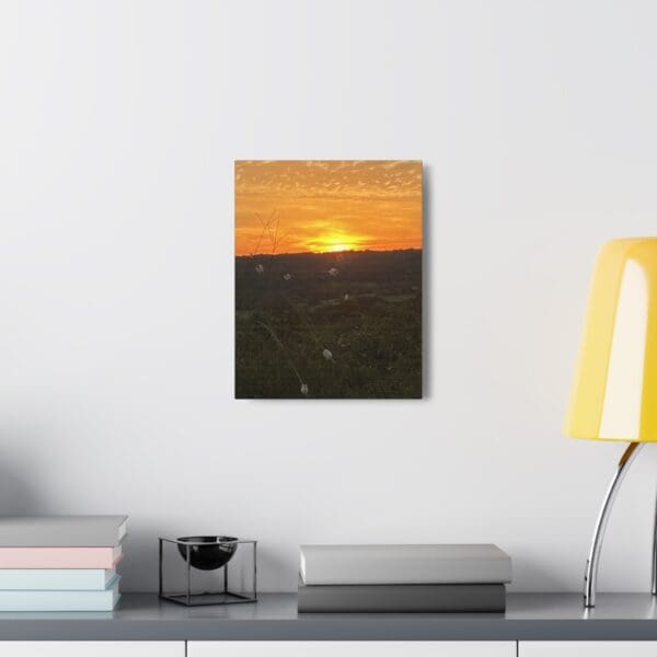 A painting of the sun setting over a field